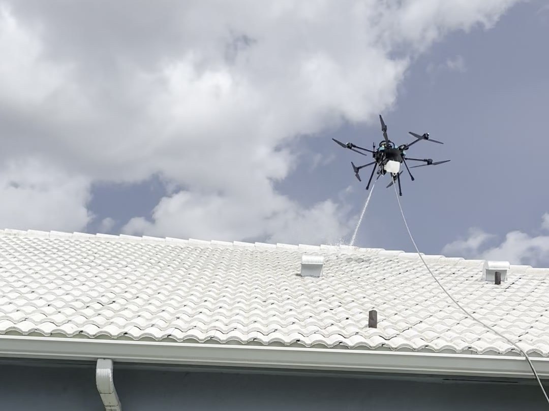 Drone soft washing a barrel tile roof